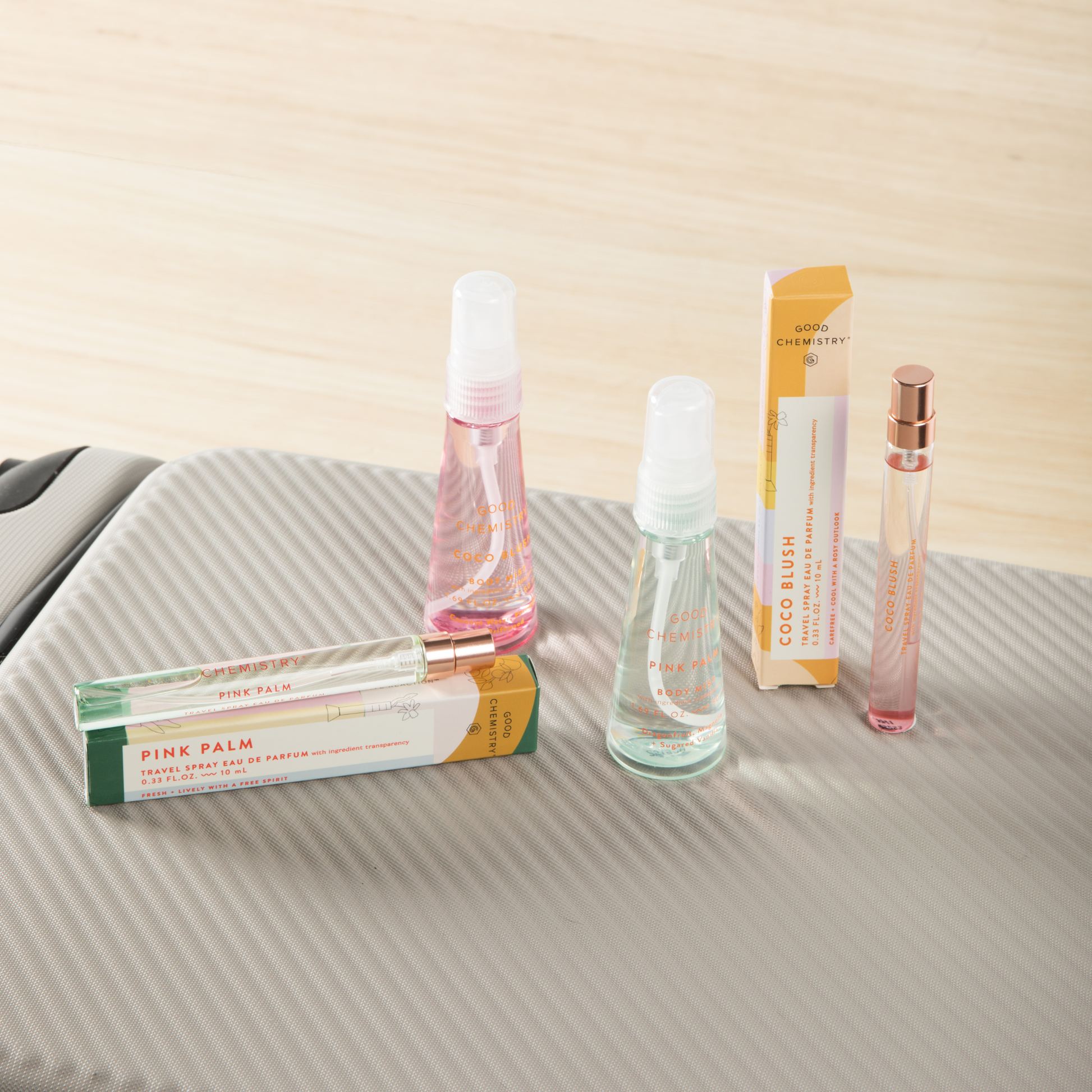 Collection of Good Chemistry travel spray products on a textured surface with a neutral background