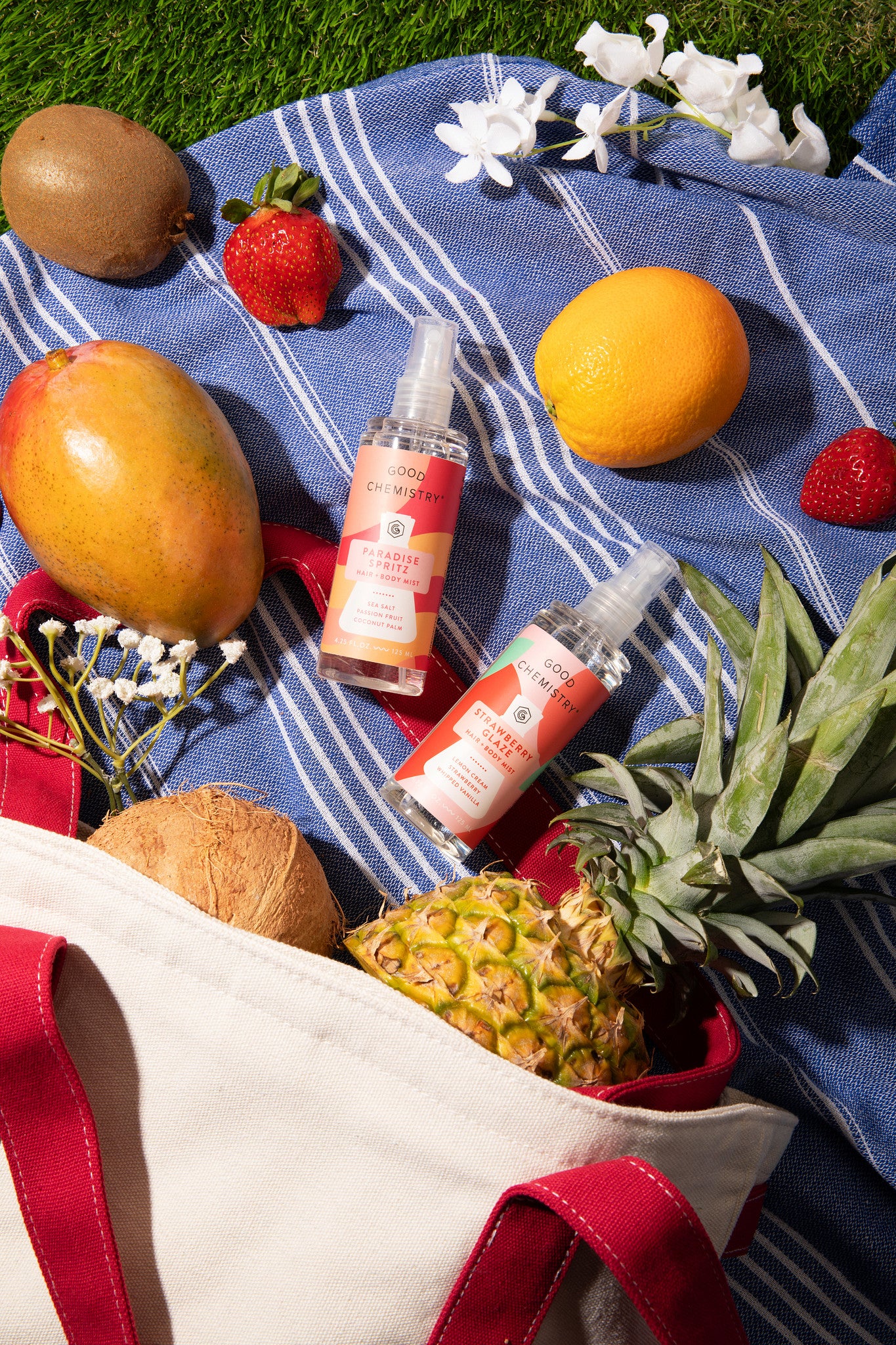 Fruits and  good chemistry limited edition summer scents on a blue blanket with a tote bag.