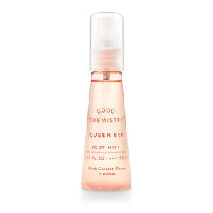 A pink spray bottle labeled 'GOOD CHEMISTRY Queen Bee Body Mist' with text indicating fragrance notes of black currant, peony, and amber.