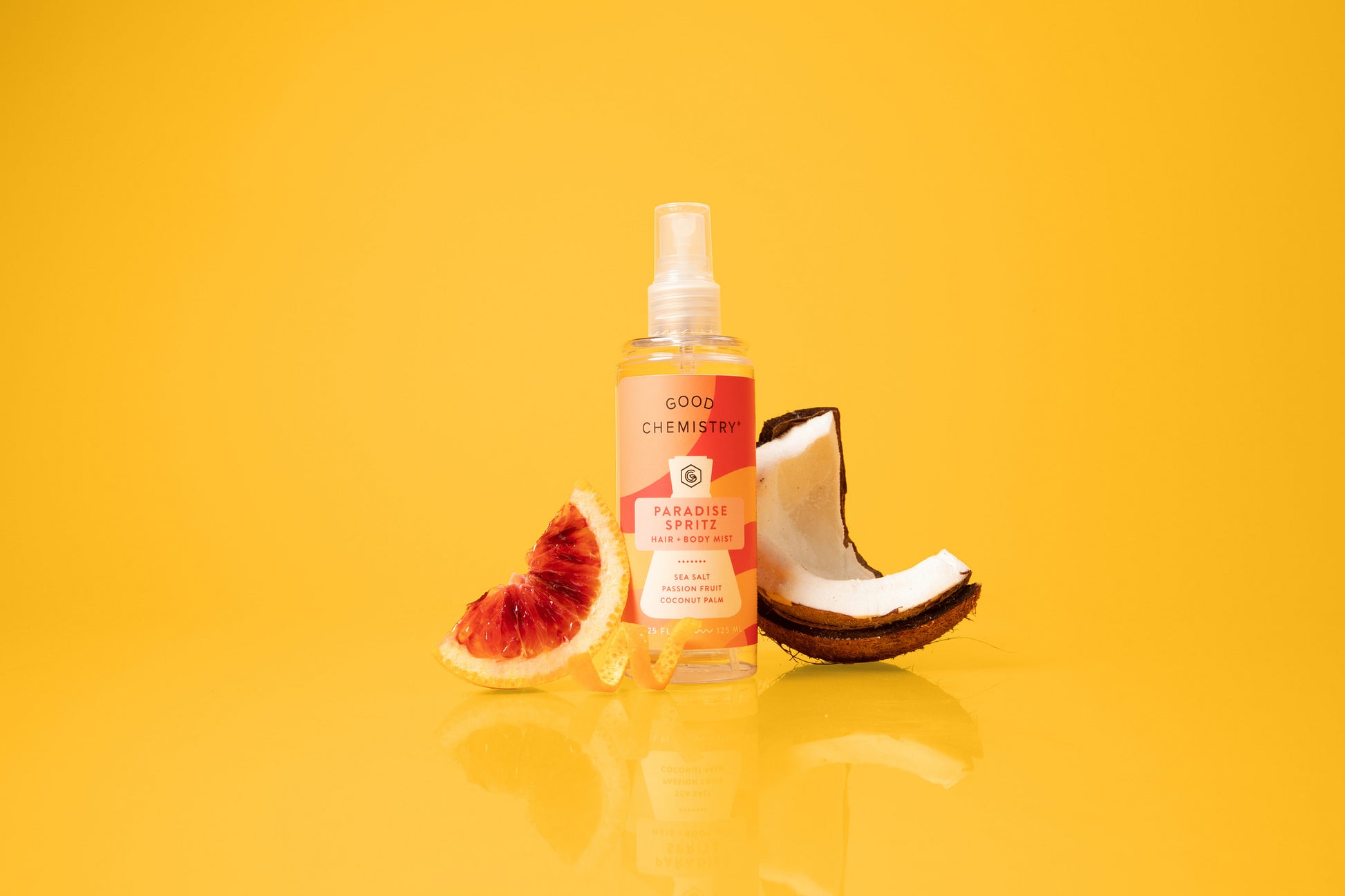Paradise Spritz spray bottle with fruit slices on a yellow background