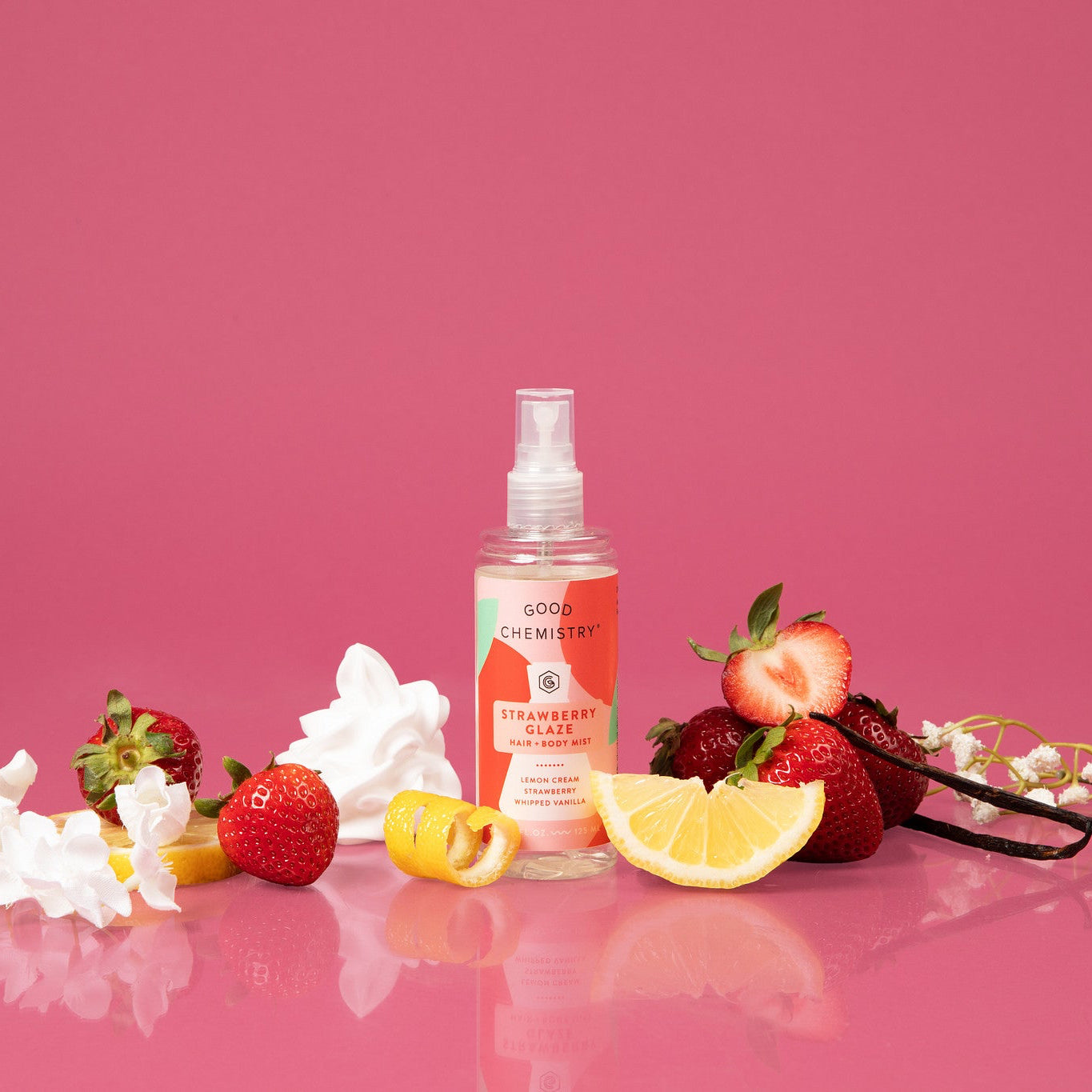 Spray bottle with strawberry and lemon on a pink background