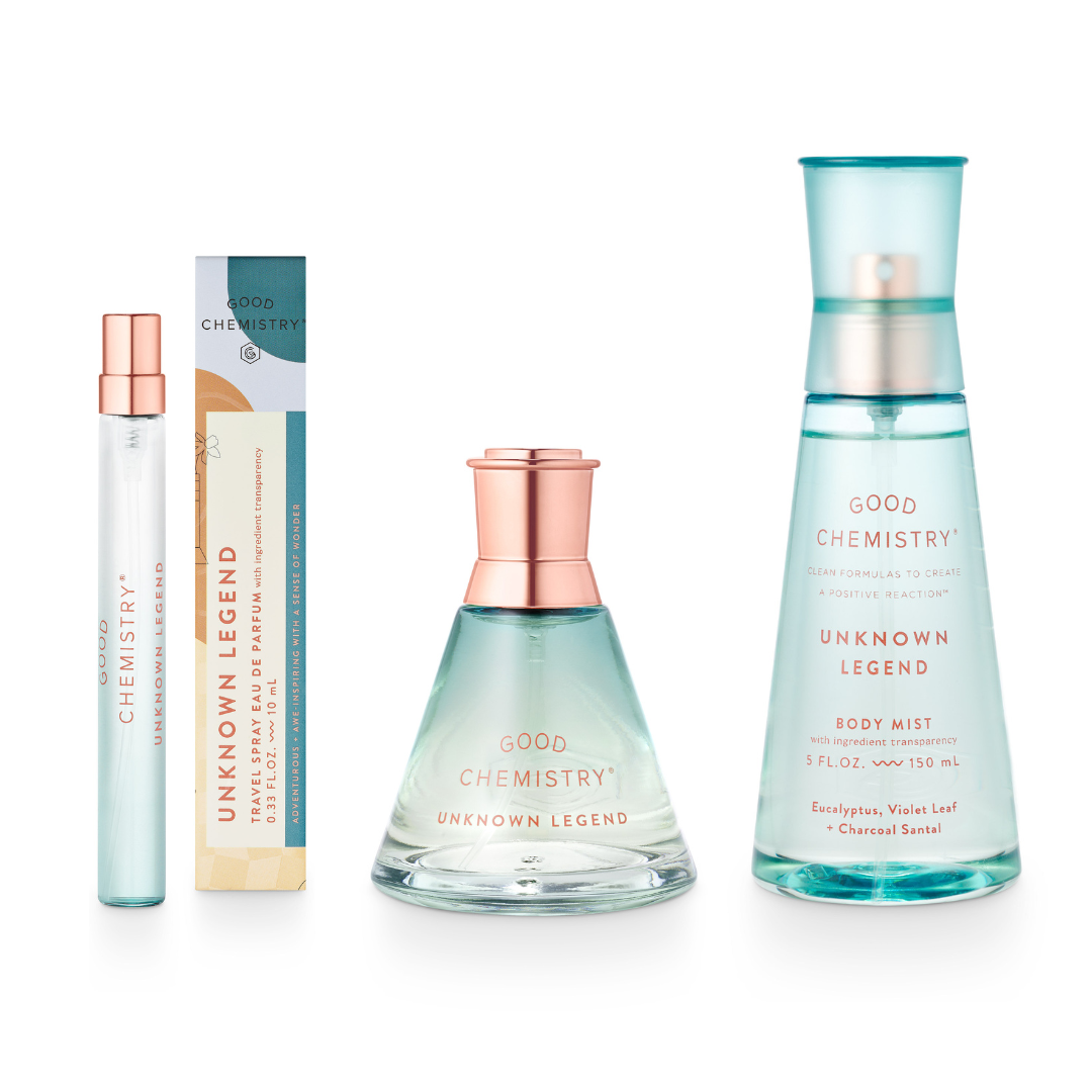 A set of three Unknown Legend fragrance bottles including a small travel spray, a medium-sized eau de parfum, and a larger body mist. The packaging is primarily light blue with floral and botanical illustrations, and the bottles contain liquids of varying concentrations for personal fragrance.