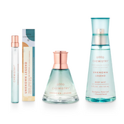 A set of three Unknown Legend fragrance bottles including a small travel spray, a medium-sized eau de parfum, and a larger body mist. The packaging is primarily light blue with floral and botanical illustrations, and the bottles contain liquids of varying concentrations for personal fragrance.