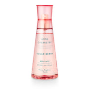A pink spray bottle labeled 'GOOD CHEMISTRY' with 'SUGAR BERRY' on the cap, describing it as a Body Mist with fragrance notes of Freesia, Raspberry, and Vanilla.
